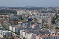 Vista aérea do Centro Sócio Cultural de Apoio à Terceira Idade: Cooperativa de Ensino do Laranjeiro e área urbana envolvente.
