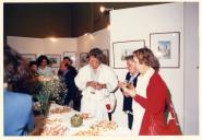 Convívio de atores em exposição de arte e beberete.
