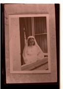Retrato de menina em janela com vestido cerimonial da primeira comunhão solene.