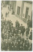 Postal com fotografia de um grupo de pessoas num largo não identificado.